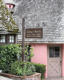 Pink cottage candy shop with woodeningle roof and sign reading Cottage of Sweets in Carmel California
