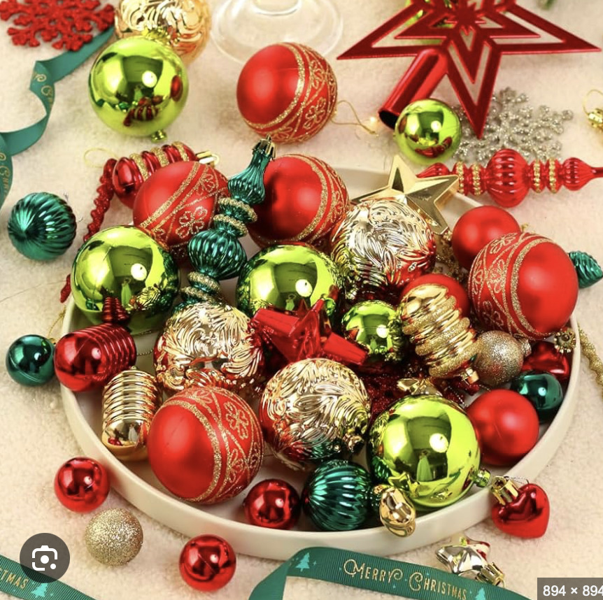 Collection of shiny Christmas ornaments in red, green, gold and silver with various shapes and textures