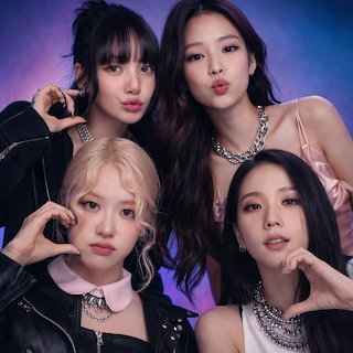 Four BLACKPINK members posing together in a studio portrait with a purple background