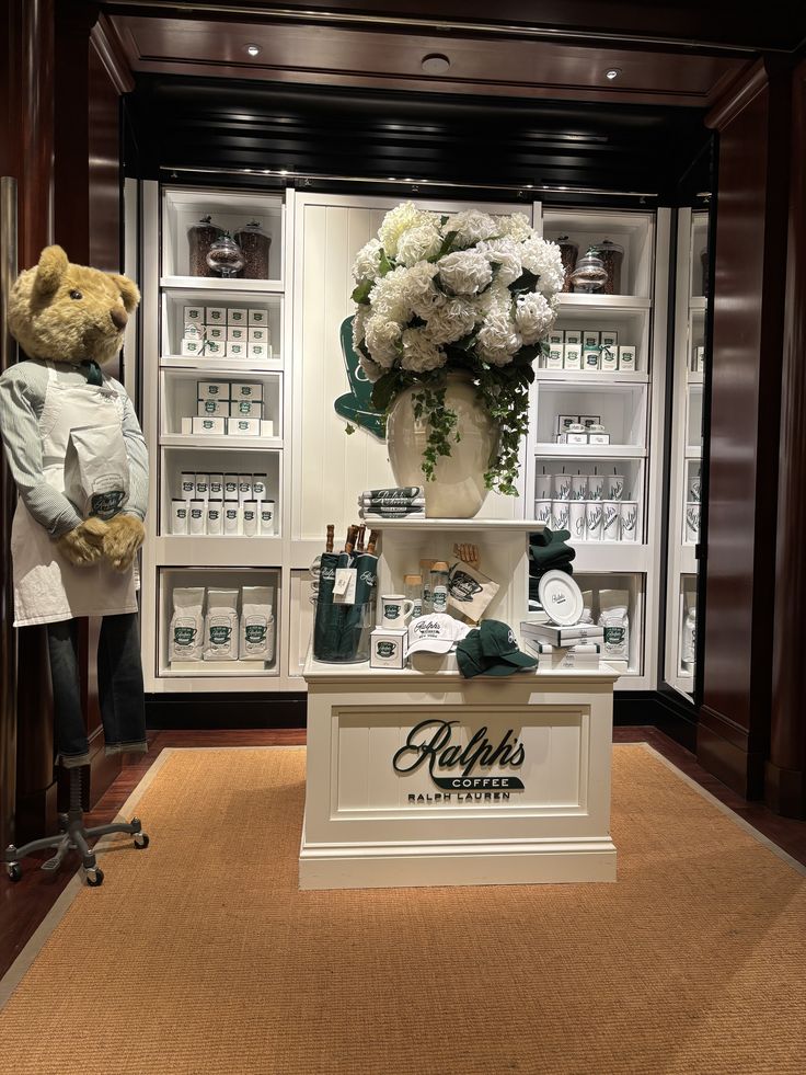 Ralph's Coffee London store interior with teddy bear, white flowers, and merchandise on shelves