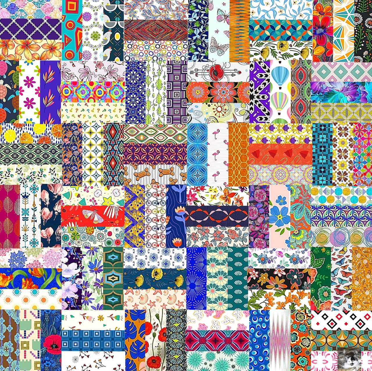 Colorful patchwork quilt with diverse patterns in grid squares including florals, animals, and geometric designs