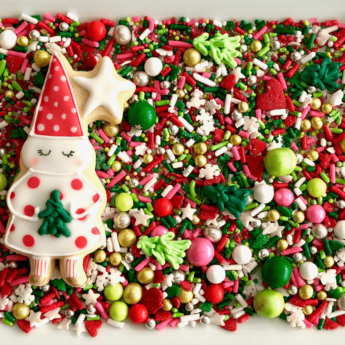 Colorful Christmas sprinkles and candies spread with decorated Santa cookie