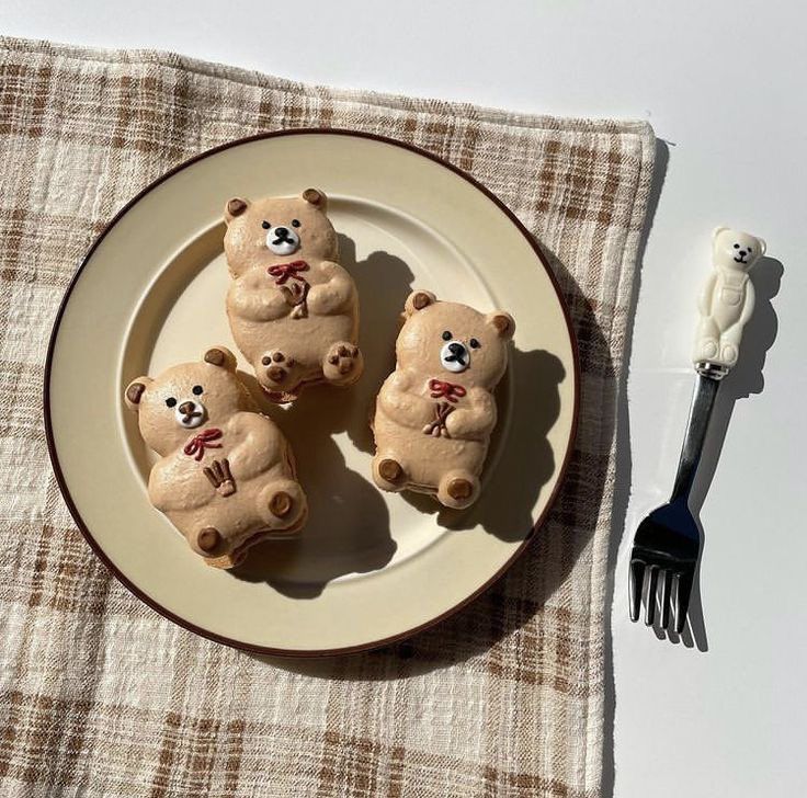 Three cute bear-shaped cookies with chocolate chip details on a cream plate