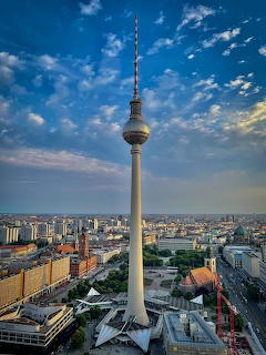Berlin TV Tower above the city skyline with blue sky and scattered clouds