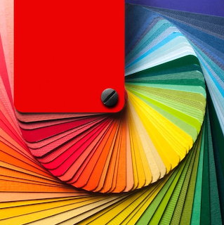 Colorful fan of paint or design swatches arranged in rainbow spectrum from red to blue