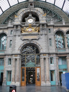 Ornate entrance arch of Antwerp Central Station with clock and glass canopy