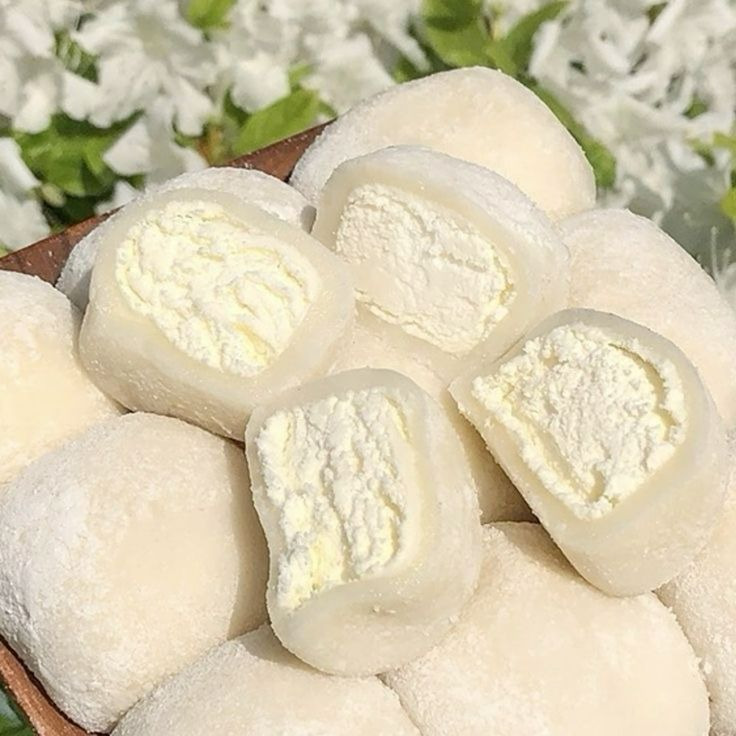 White mochi rice cakes with cream filling on wooden tray
