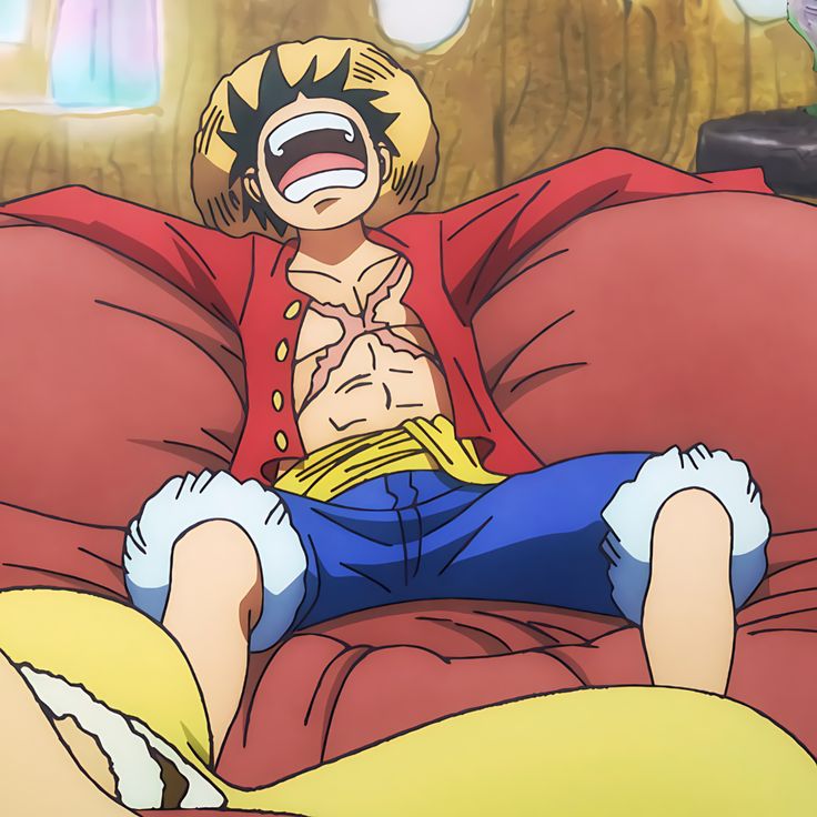 Luffy from One Piece laughing on red couch in straw hat