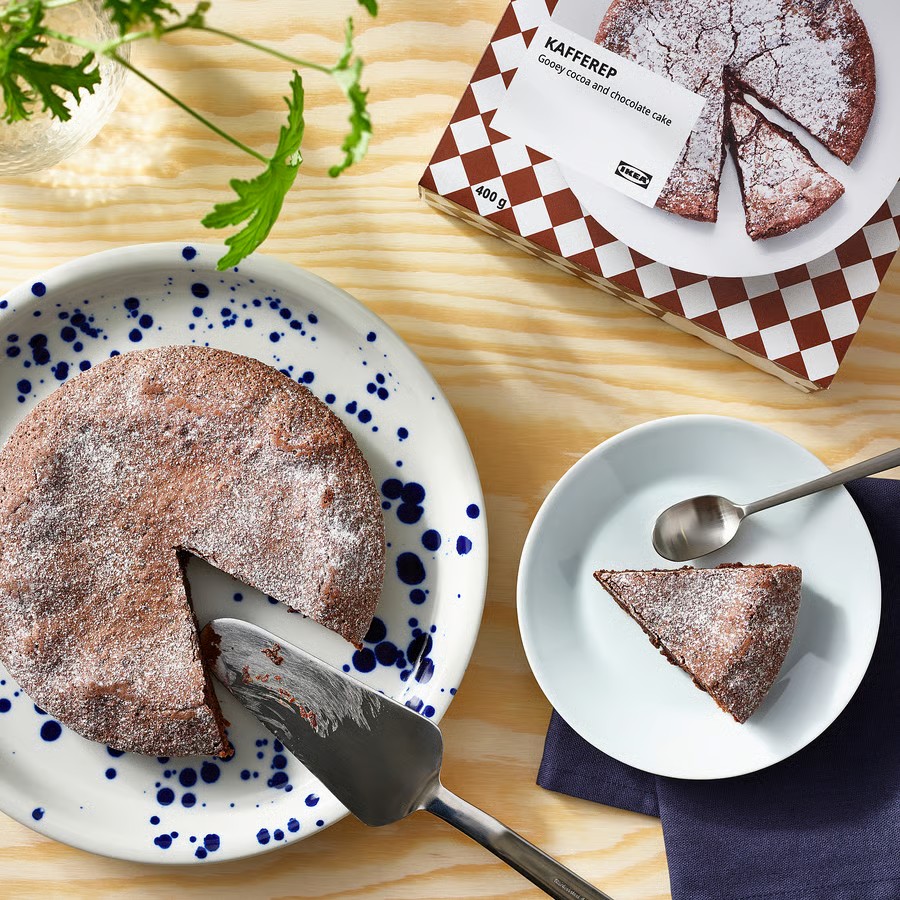 Overhead view of chocolate cake slices on plates with polka dot and checkered patterns on wooden table