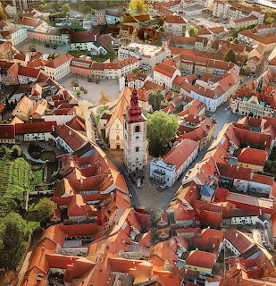 Aerial view of Ptuj old town with red roofs and church tower in central square