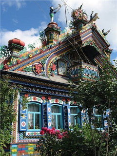 Colorfully painted ornate wooden house with floral decorations and bright trim