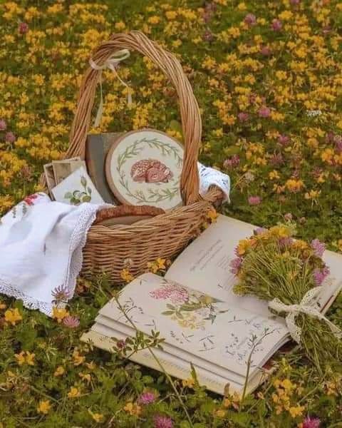 Vintage vignette of hands collecting wildflowers beside a botanical identification book.