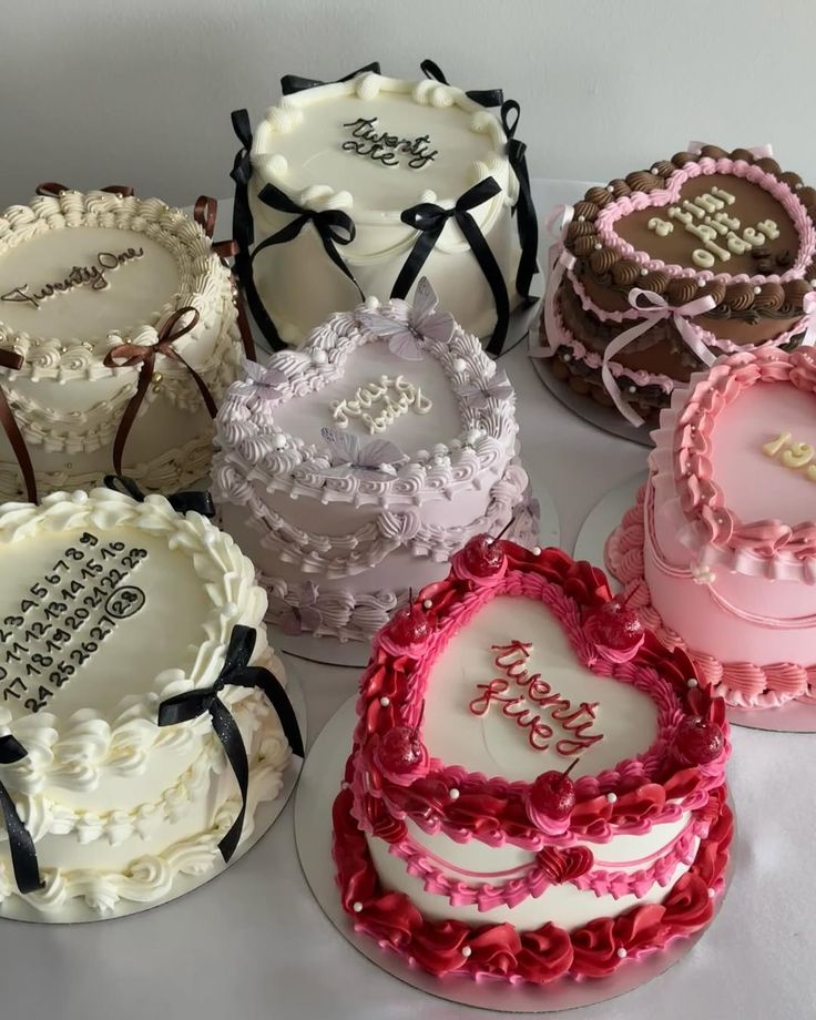 Collection of decorated heart-shaped cakes with pastel frosting and floral details