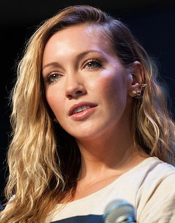 Portrait of blonde woman with wavy hair looking to the side at an event
