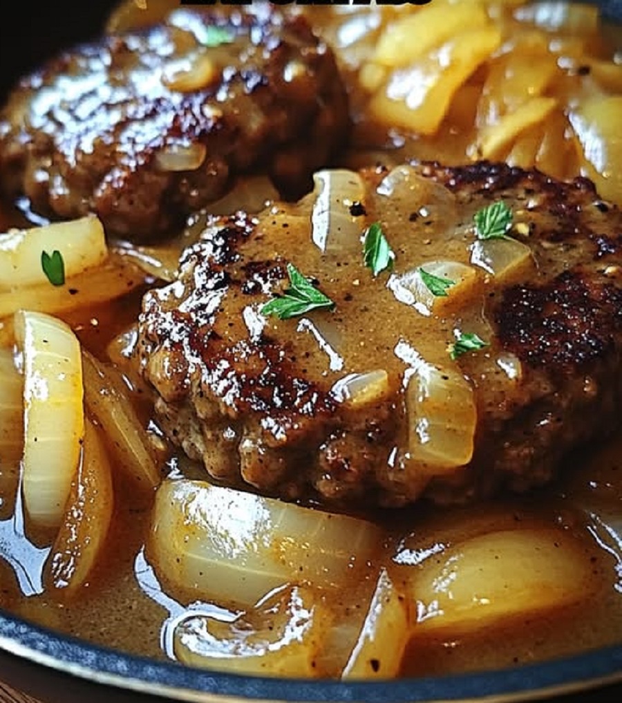 Hamburger steak with caramelized onions and gravy, served alongside roasted potato wedges