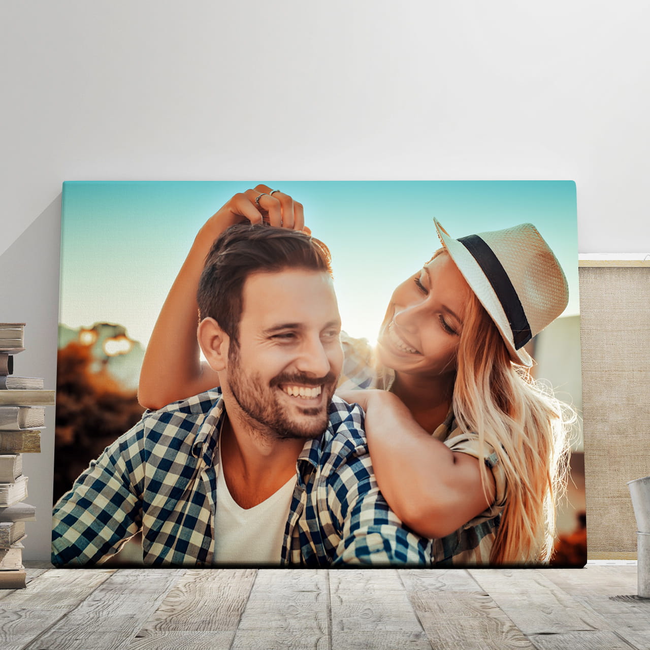 Smiling young couple in a close portrait, with the woman wearing a hat and leaning on the man's shoulders