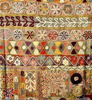 Decorative ethnic fabric with geometric patterns and floral embroidery in horizontal bands