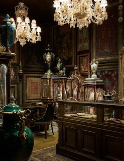 Elegant antique store interior with crystal chandeliers, ornate furniture, and decorative objects in glass cases