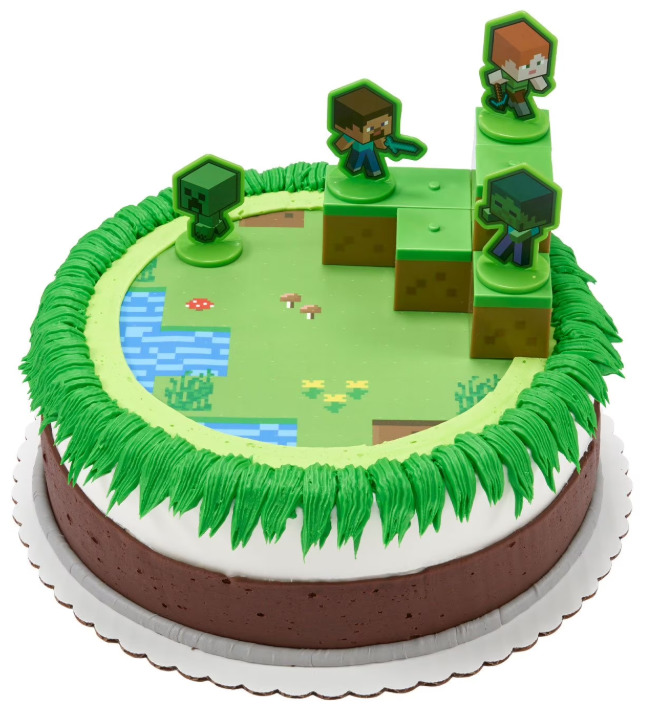 Minecraft themed cake with green fondant, pixelated landscape, and character figurine topers