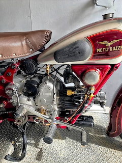 Vintage Moto Guzzi motorcycle engine with red tank and brown leather seat