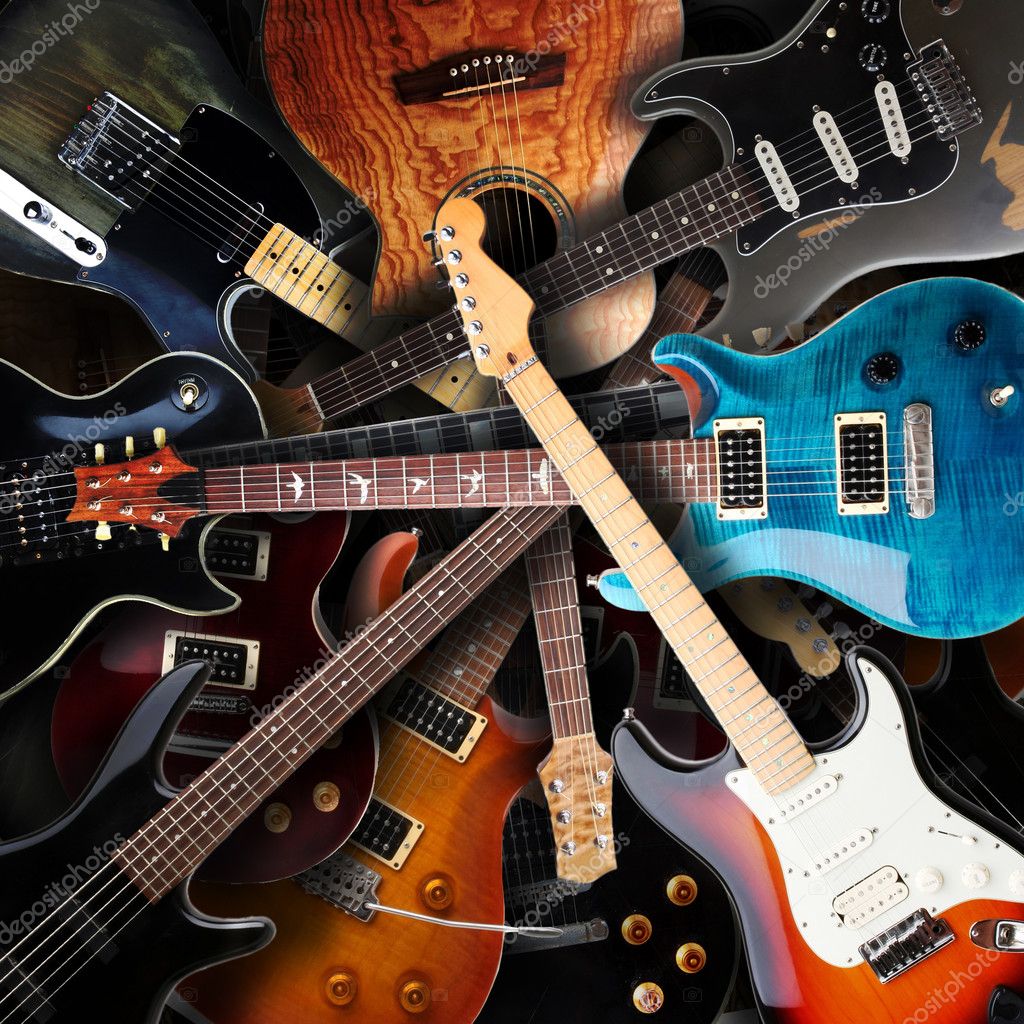 Close-up of several overlapping electric and acoustic guitars in different colors and finishes