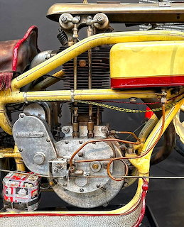 Close-up view of a vintage yellow motorcycle engine with chrome details and red trim