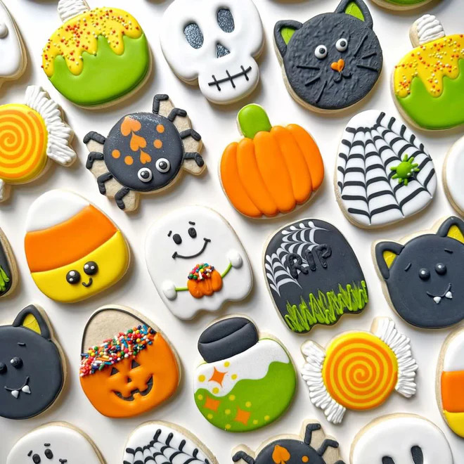 Assortment of decorated Halloween sugar cookies with pumpkins, ghosts, cats, and spiders