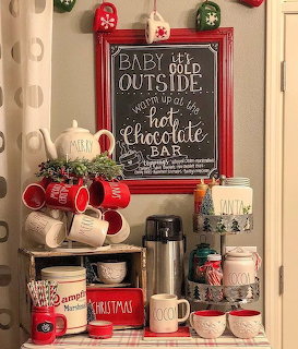 Christmas coffee bar with chalkboard sign, red mugs, ornaments, and holiday decorations