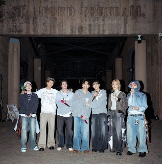 Group of casually dressed young people standing under a stone archway at night