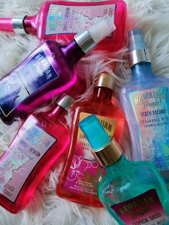 Colorful body spray and lotion bottles on a fluffy white background
