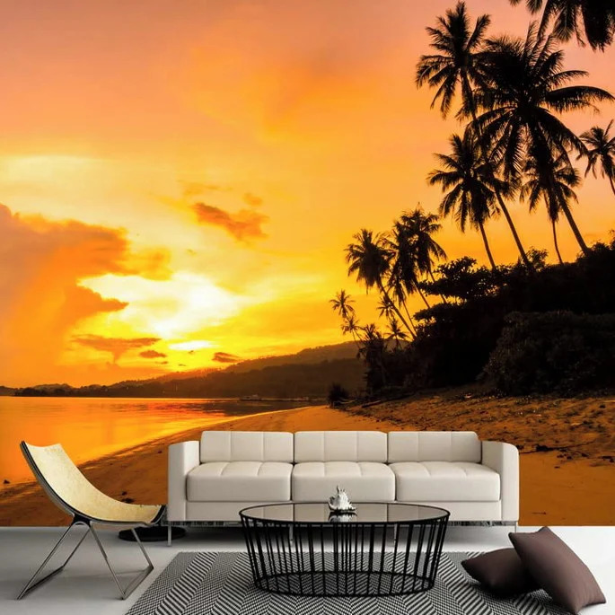 White sofa, chair, and table on a tropical beach at sunset with palm trees