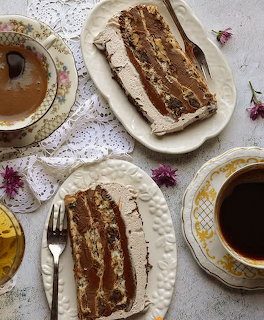 Two slices of layered cake with cups of coffee on a lace tablecloth
