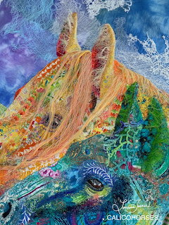 Textile art of two horses made with colorful fabric, embroidery and mixed media on blue background
