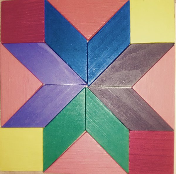 Geometric star pattern made of multicolored shapes on yellow background