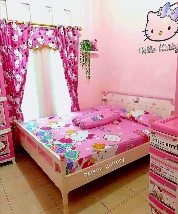 Pink Hello Kitty themed bedroom with matching curtains, bedsheets, and wall decoration