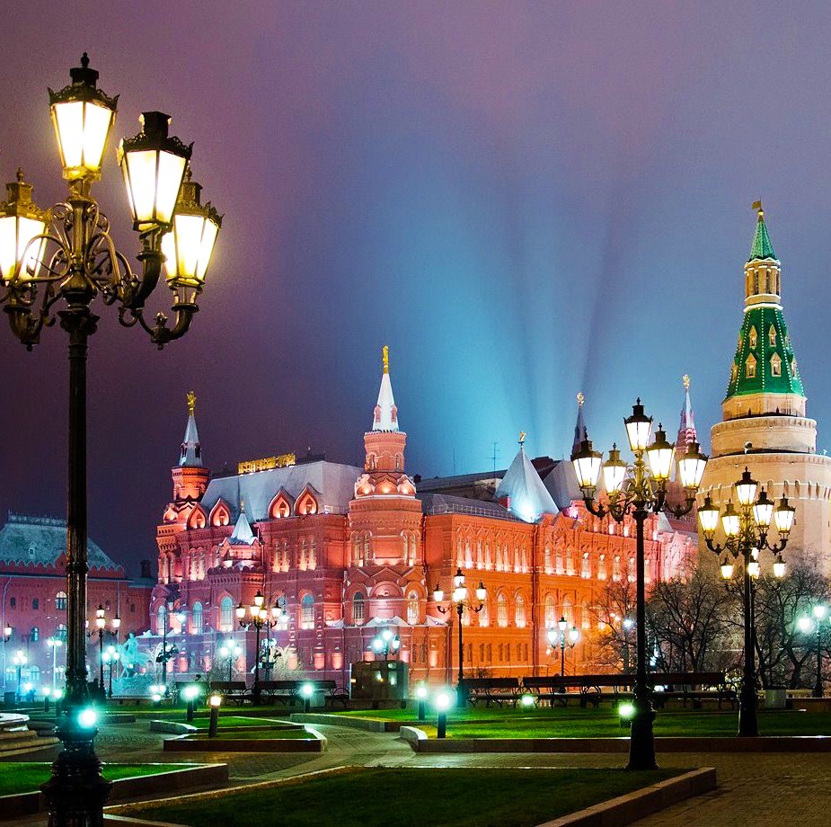 Illuminated Red Square buildings in Moscow at twilight with ornate street lamps and dramatic sky