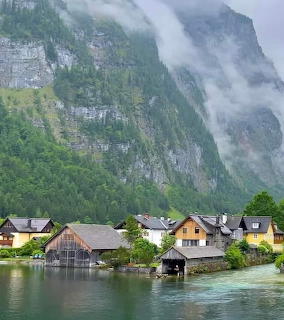 Lakeside village houses below a misty mountain in Hallstatt, Austria