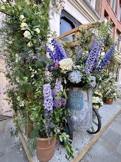 Large floral display with purple and white flowers outside a London storefront