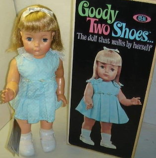 Vintage Goody Two Shoes doll in blue dress next to original black product box