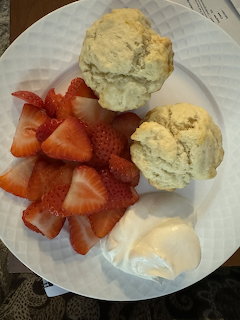 Strawberry shortcake with biscuits, fresh strawberries, and whipped cream on a white plate