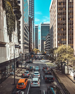 Downtown Vancouver street with cars and tall office buildings under a blue sky