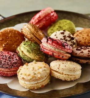 Assorted colorful French macarons in various flavors arranged on a round plate