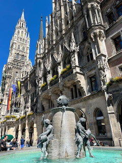 Bronze fountain with figures in front of Munich's Gothic New Town Hall tower at Marienplatz