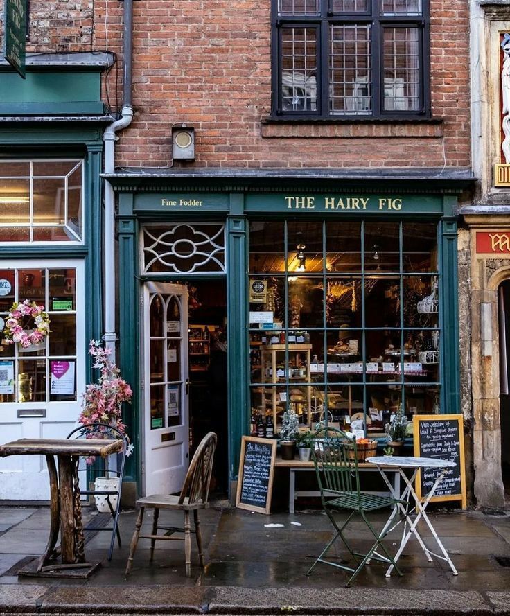The Hairy Fig shop front in York with green painted facade, outdoor tables and chairs on a cobbled street