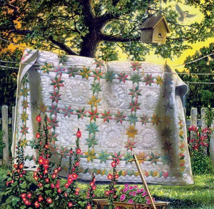 Patterned quilt hanging on a clothesline in a flower garden beneath a tree and birdhouse