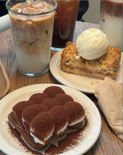 Tiramisu, apple pie with ice cream, and iced coffee arranged on a table