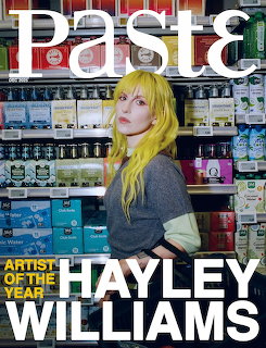 Woman with yellow and green hair posing in a store aisle on a magazine cover