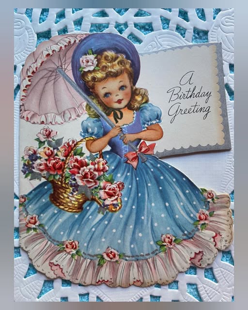 Vintage birthday card showing girl in blue dress with flowers and lace border