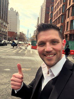Smiling man giving a thumbs up on a New York City street