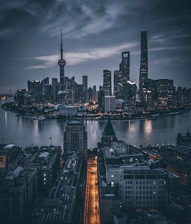 Shanghai city skyline at night with illuminated skyscrapers and Huangpu River
